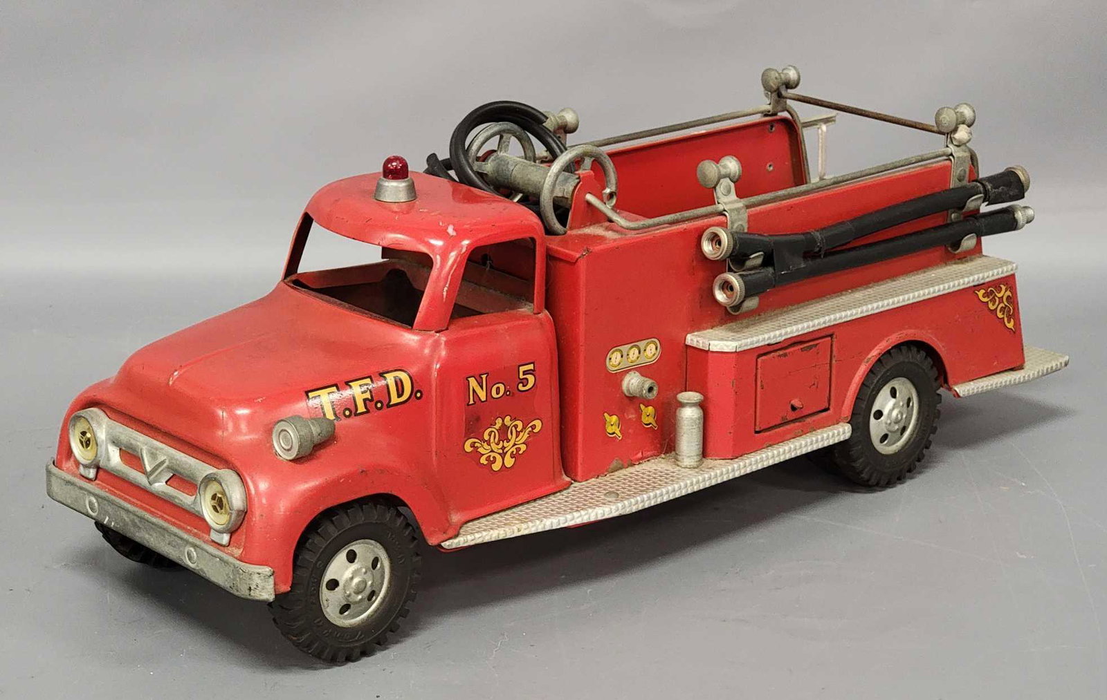 1950s Tonka Fire Pumper: 1950s Tonka Fire Pumper. Truck is good with paint rubs and scratches throughout. The reel hose is cut and missing the nozzle. Comes with ladder and two straight hoses.
