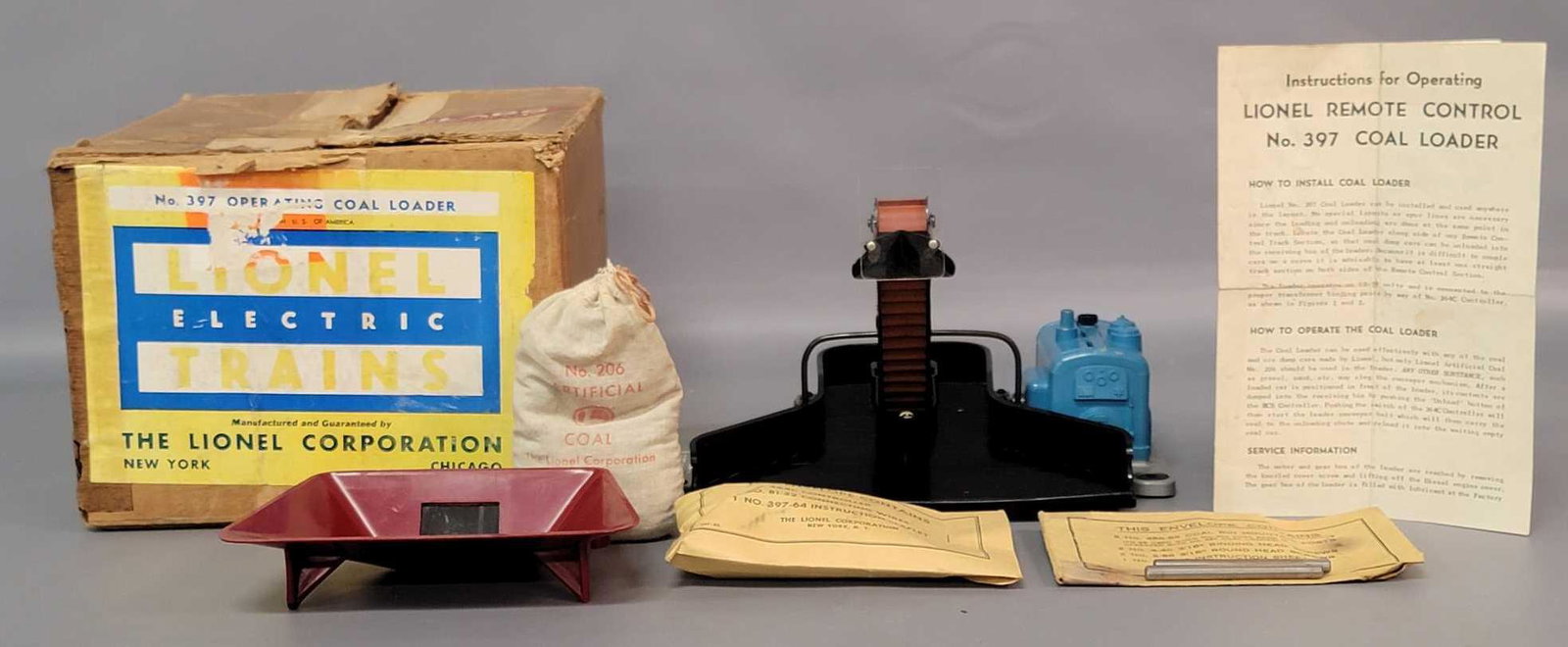 Postwar Lionel O gauge 397 operating coal loader in: Postwar Lionel O gauge 397 operating coal loader in original box with black tray, C7 with normal red bin. Sealed 397-53 envelope. 456-5 opened envelope with bin posts. Instructions sheet, and 206 arti