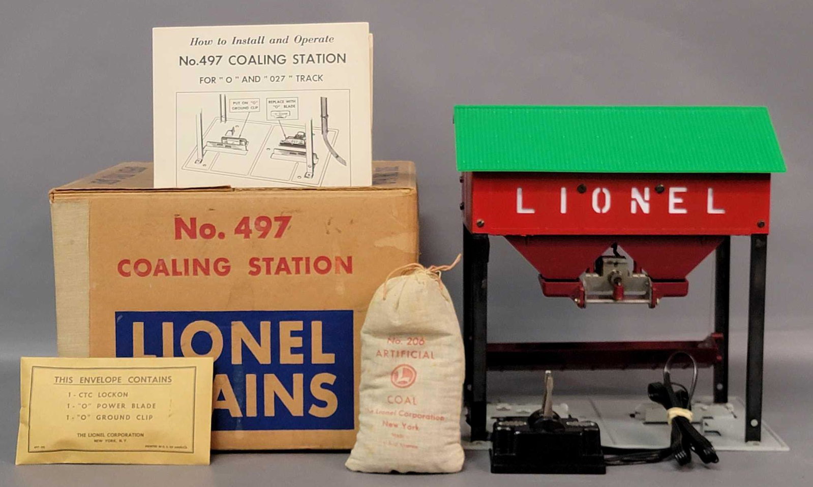 Postwar Lionel O gauge 497 coaling station in original: Postwar Lionel O gauge 497 coaling station in original box with components in envelope, 206 bag of artificial coal, and controller. Coaling station is incredibly clean and shiny C6. Box has a little t