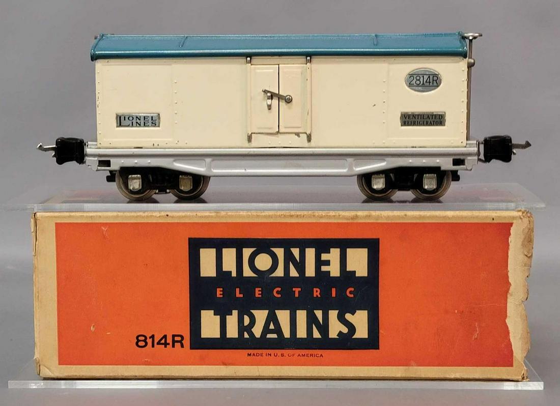 Prewar Lionel O gauge 2814R refrigerator car in: Prewar Lionel O gauge 2814R refrigerator with ivory body, light blue roof, aluminum frame, nickel trim and plates, C7. Box is missing flaps on one end, otherwise square and solid.