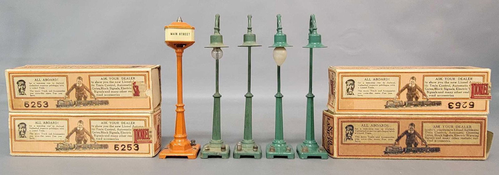 Prewar Lionel O gauge group of lamp posts and street: Prewar Lionel O gauge accessories, four 58 single gooseneck lamp posts, and a 57 street sign, nicer C6. Four 58 boxes with missing flaps, square and solid.