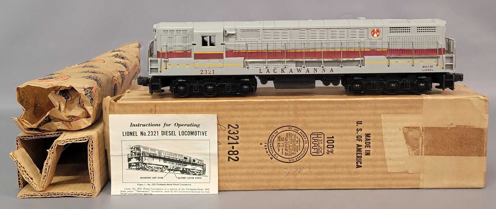 Postwar Lionel O gauge 2321 gray Lackawanna diesel in: Postwar Lionel O gauge 2321 gray Lackawanna Fairbanks Morse Trainmaster diesel locomotive in original box with insert, wrapping paper, and instructions sheet. Train has typical hairlines at both screw