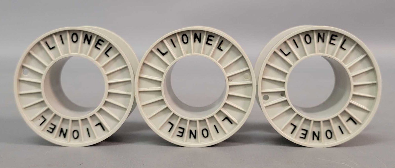 Postwar Lionel O gauge gray cable reels with black: Three postwar Lionel O gauge gray cable reels with black lettering, C9-10. Rare item.