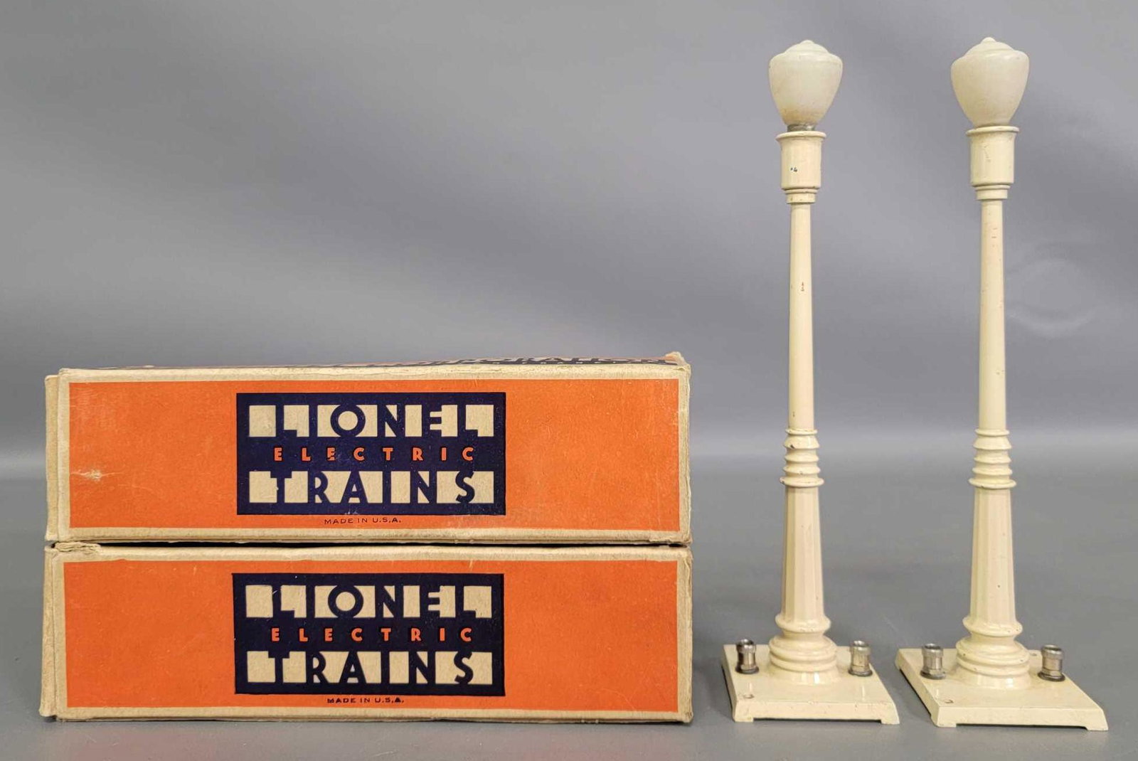 Two Lionel prewar O 53 street lamps in original boxes: Two Lionel prewar O 53 street lamps in original boxes, one appears to be cream while the other is ivory, C6+ in incomplete original boxes as seen in the photos..