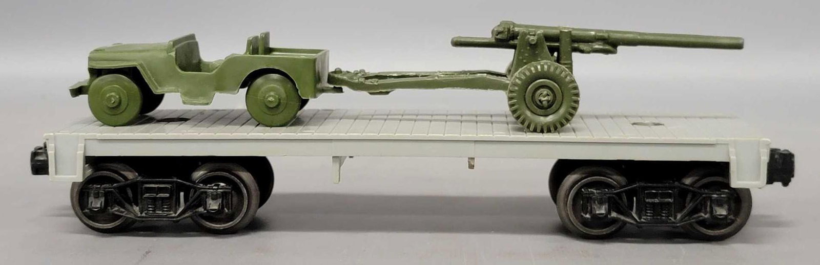 Lionel postwar O 6801 flat car with jeep and howitzer: Lionel postwar O 6801 flat car with jeep and howitzer. Both load pieces are an olive drab color and apparently incorrect for what would have been issues by Payton for the 19434 set which would have be
