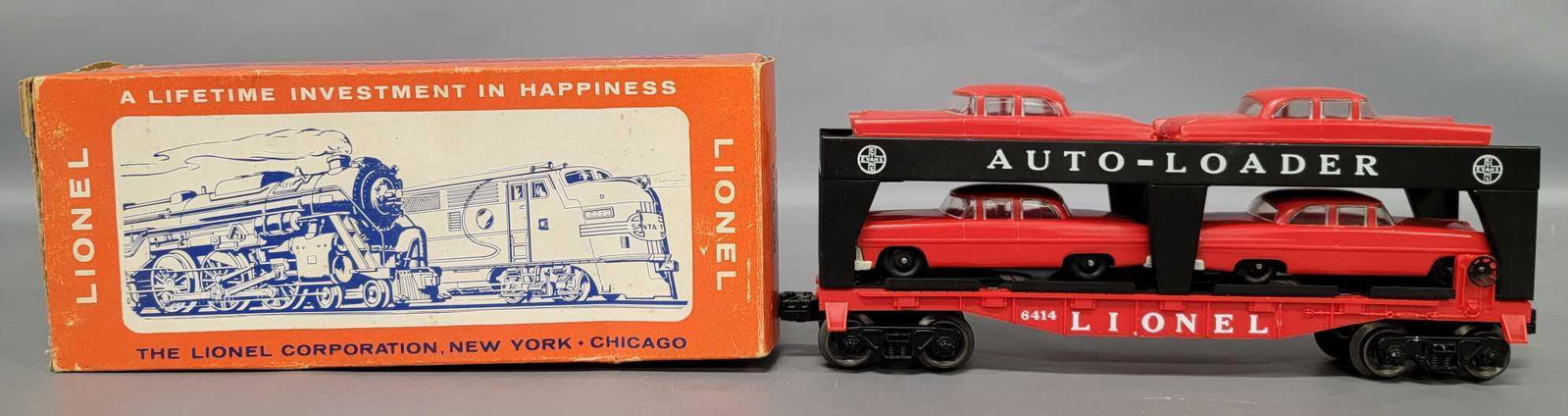 Lionel postwar O 6414 autoloader with four RED autos in: Lionel postwar O 6414 autoloader with four red autos in original box, car shows light run time and is C8-9 with four C9 gray bumper autos in a good original box.