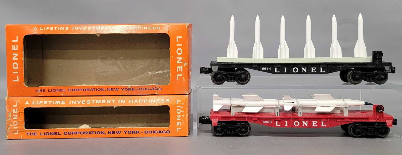 Lionel postwar O 6844 6823 military cars in OBs: Lionel postwar O 6844 missile carrying car and 6823 flat car with missiles in original boxes. Both cars show moderate run time but are C7+ with fair to good original boxes that both have tape repa