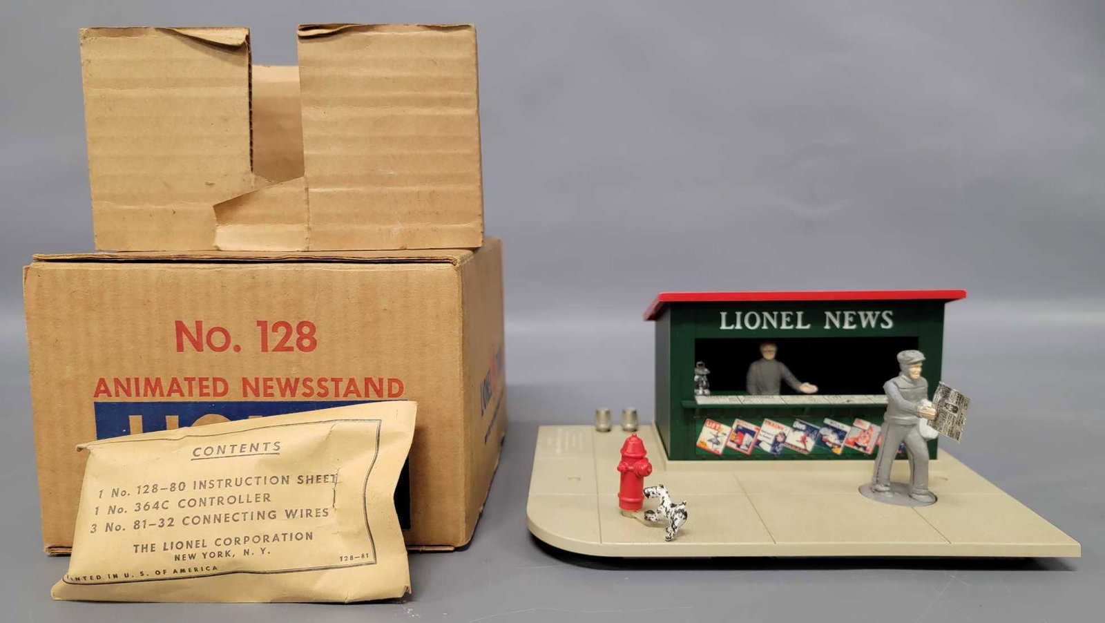 Lionel postwar O 128 animated newsstand in original box: Lionel postwar O 128 animated newsstand in original box, C8 with a sealed 128-81 parts packet and the man has the metal newspaper still in his hand. Comes in a very good to excellent original box with
