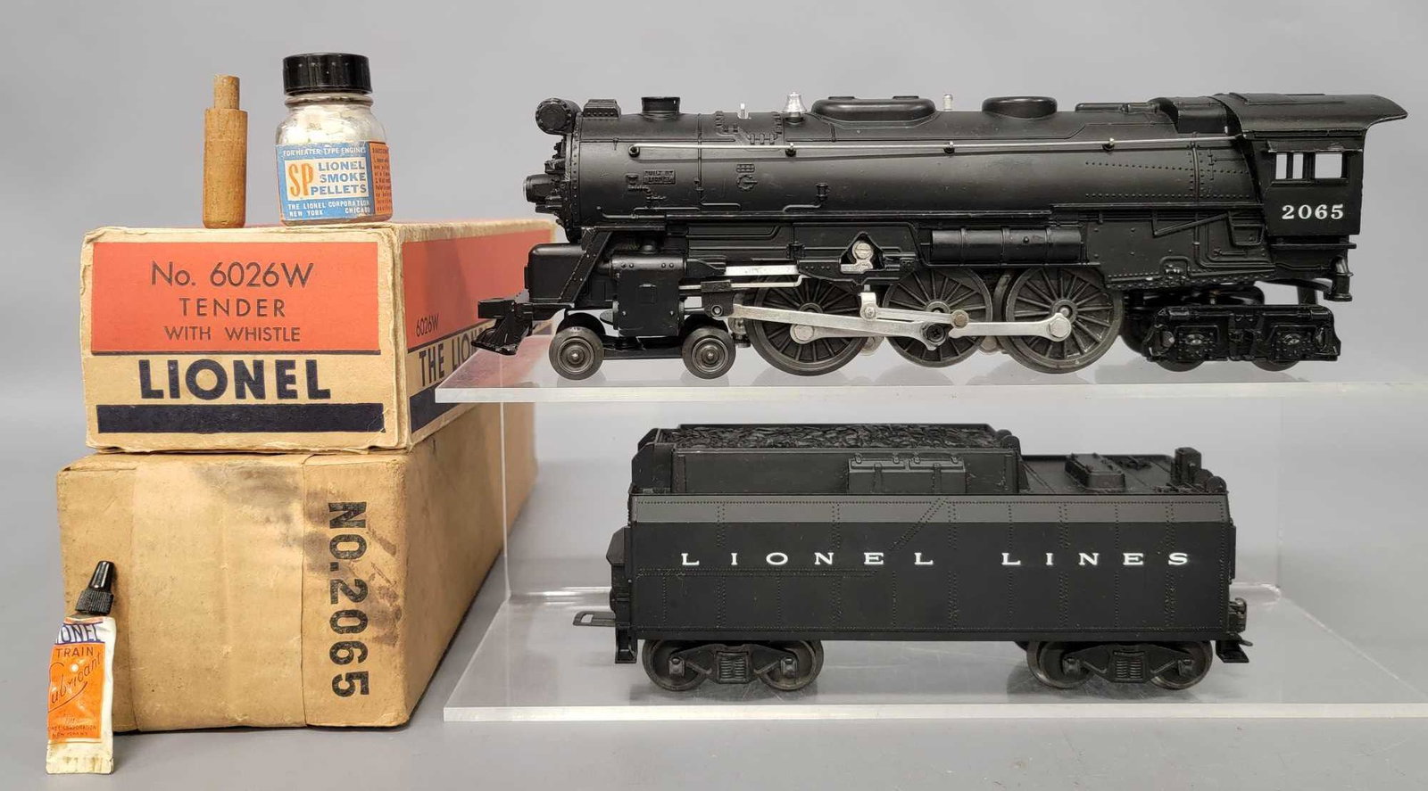 Lionel postwar O 2065 steam locomotive with 6026W: Lionel postwar O 2065 steam locomotive with 6026W tender in original boxes. Both show light run time and are C7. Comes with a very good locomotive box and a fair to good tender box, bottle of smoke pe