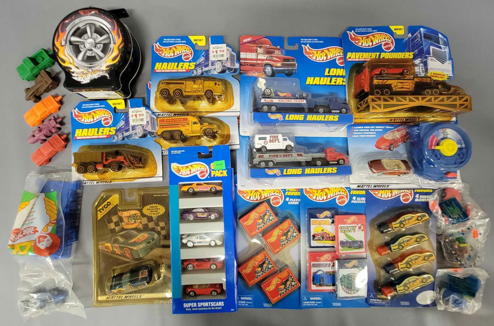 Large Lot of Hot Wheels cars and Accessories: Large Lot of Hot Wheels cars and Accessories. Group contains an assortment of items including a Super Sportcars 5 pack, six different Long Haulers on cards, a carded Power Launcher, a TYCO 30th Annive