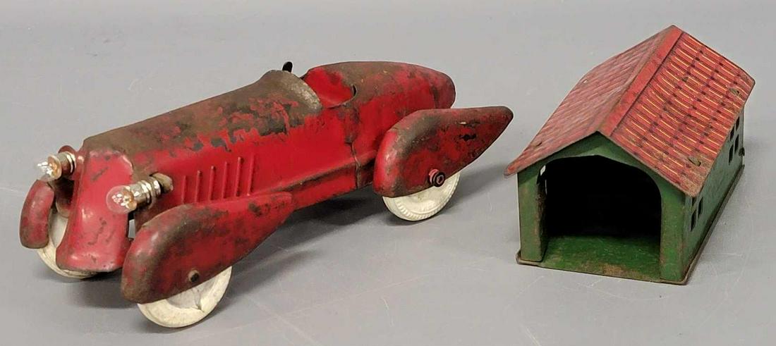 Unmarked pressed tin building and car: Unmarked pressed tin building and car. Building is in good condition with no major areas of paint loss, car has a lot of wear, it looks as if it would have had a battery setup of some sort as the head