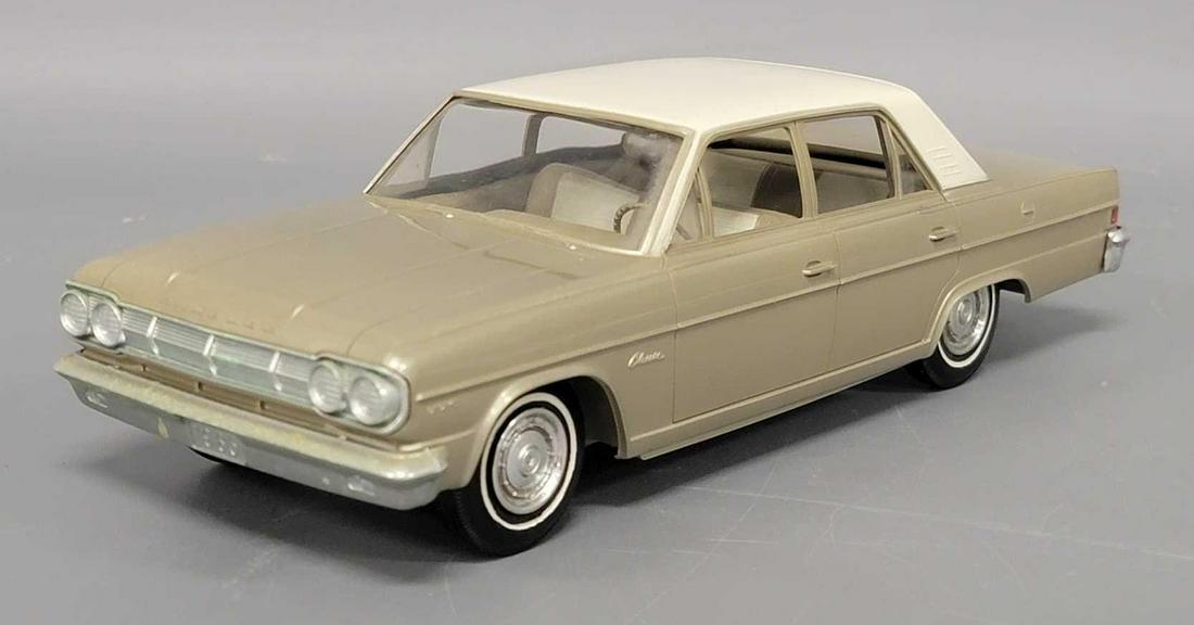 1965 gold AMC Rambler 4 door dealer promo coaster car: 1965 gold Rambler 4 door dealer promo coaster car, car is excellent plus with a small box rub mark on front of roof edge, light chrome fade in spots on bumpers.