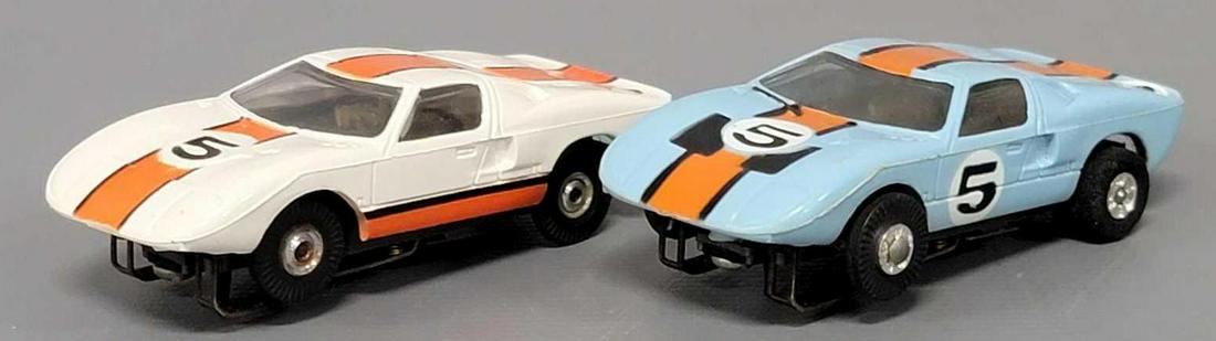 Two Aurora Model Motoring T-jet Ford GT Flamethrower slot cars: Two Aurora Model Motoring T-jet Ford GT Flamethrower slot cars, includes both a blue and a white version, both are in excellent condition, motor on blue tested and runs, white did not run when tested.