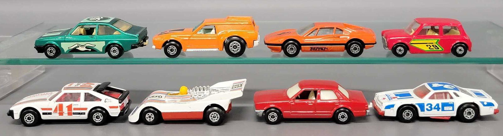 Seven Matchbox cars: Seven Matchbox cars, includes green Ford Escort with Seagull decals, #34 Chevy Pro Stocker, red with opaque windows Ford Cortina, orange Ferrari 308, Toyota Supra Rally car, MB Hi Tailer, Racing Mini,