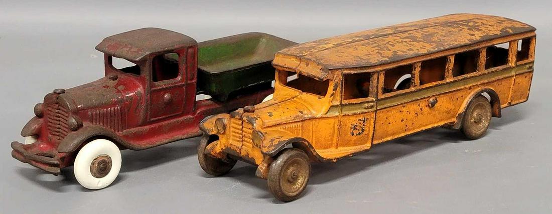Two Vintage Cast iron toy trucks: Vintage Cast iron toy trucks, includes Arcade Mfg orange six window bus, measures 9 1/4 inches long, in good condition with no cracks or breaks, it has wooden wheel hubs, paint is fair, missing driver