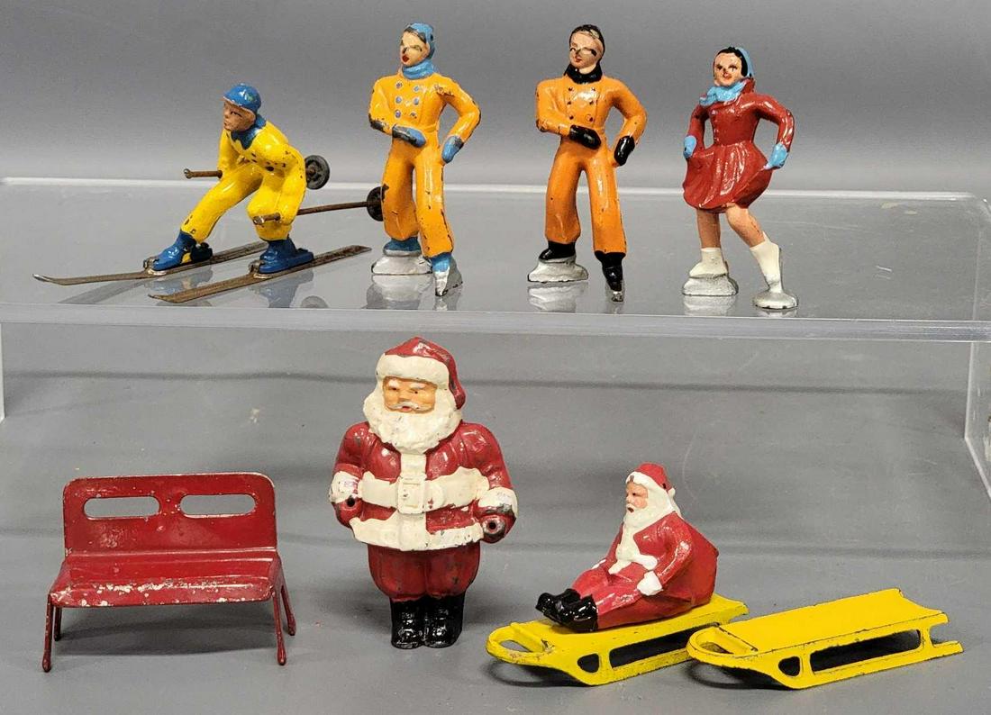 Eight piece collection of painted cast lead Barclay winter figures: Eight piece collection of painted cast lead Barclay winter figures, includes Santa on a sled, a skiing Santa that is missing its poles and skis, a couple of ice skaters, a male ice skater, all are in 
