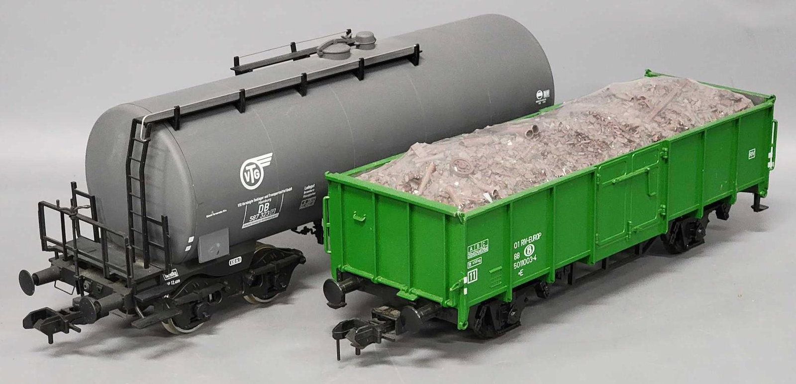 Two Marklin Gauge 1 train cars: Two Marklin Gauge 1 train cars, includes green gondola with scrap load (still factory wrapped in cello), marked 01 RIV-Europ, car is C7 with a few light scratches, the other car is a grey gray tanker 