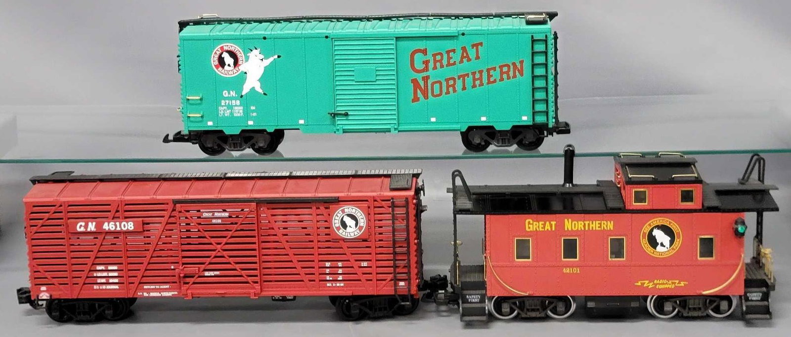 Two mixed G Gauge maker freight cars with caboose: Two mixed G Gauge maker freight cars with caboose, includes an LGB Great Northern Railway green box car with baggie of parts included, appears C7 lightly run if at all, an Aristo-craft red Great North