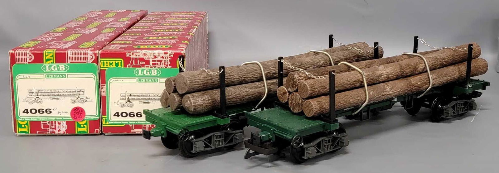 Two LGB G Gauge #4066 flat car with log loads in original boxes: Two LGB G Gauge #4066 flat car with log loads in original boxes, both are almost identical with dark logs, silver chains and grey gray trucks, the only difference is one has a glossy green flat car, t