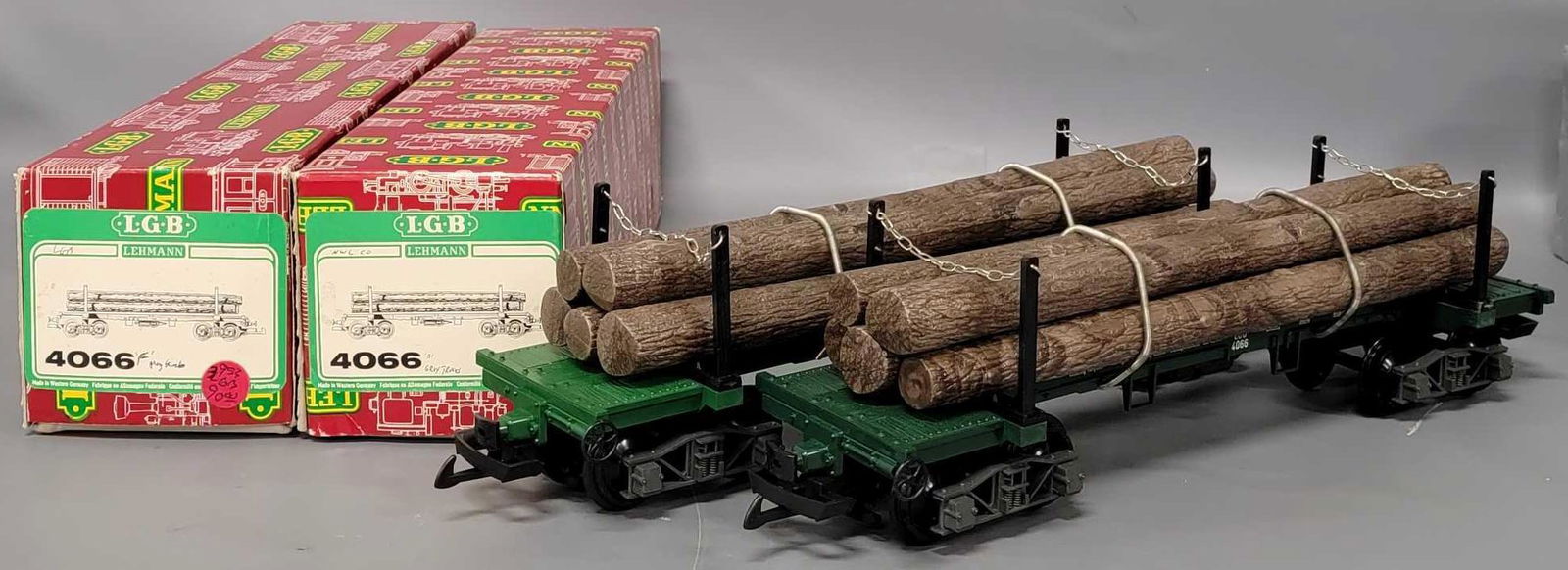 Two LGB G Gauge #4066 flat car with log loads in original boxes: Two LGB G Gauge #4066 flat car with log loads in original boxes, both are almost identical with dark logs, silver chains and grey gray trucks, the only difference is one has a glossy green flat car, t