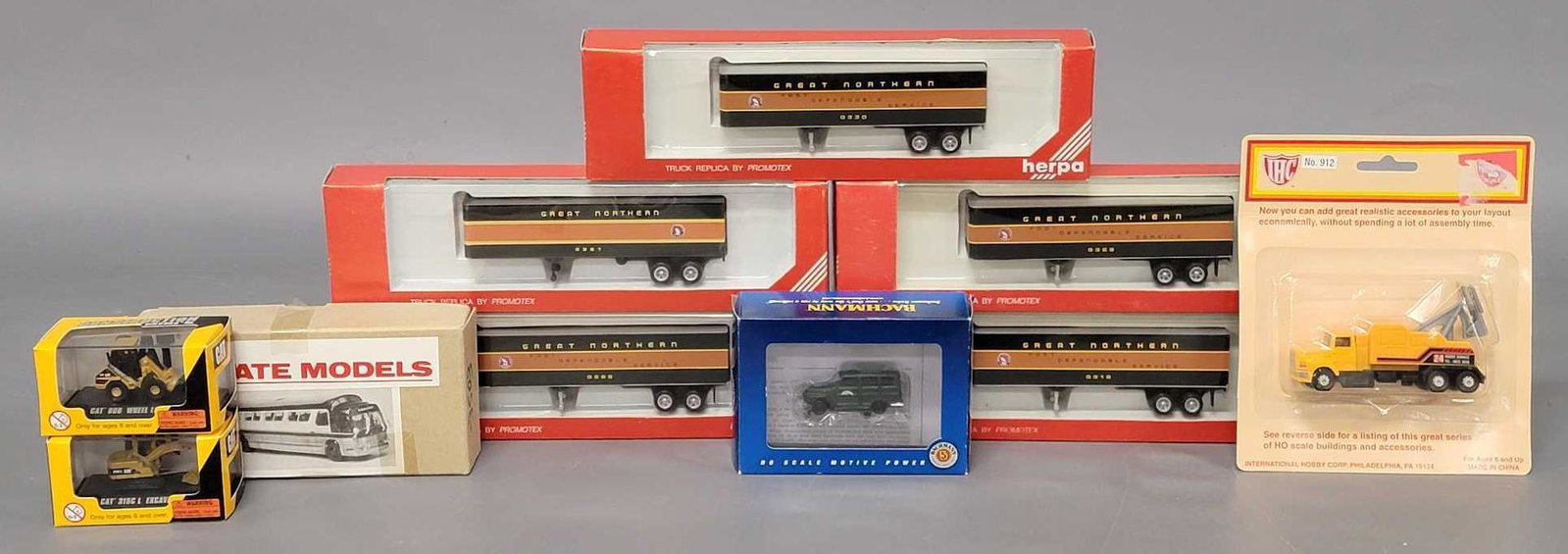 Ten assorted manufacturer HO scale vehicles in original boxes: Ten assorted manufacturer HO scale vehicles in original boxes, includes five Herpa Great Northern trailers, an IHC Semi tow truck, two Norscott models Caterpillar vehicles including 906 wheel loader a