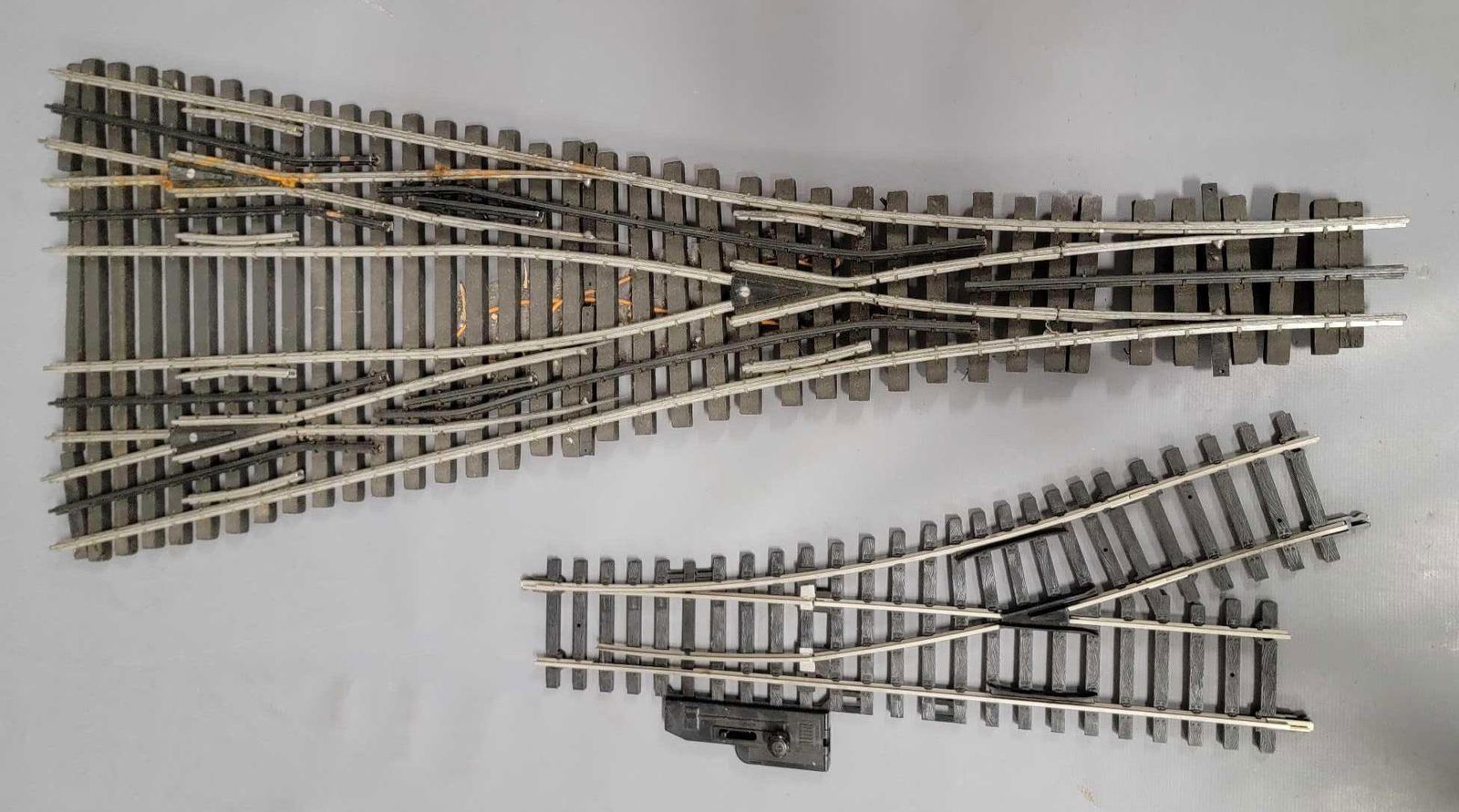 O Scale four way train track switch used: O Scale four way train track switch used, piece has no switch mechanisms on it, has wires connected to the bottom, it needs work to get it in working condition, nothing seems broken, needs some cleani