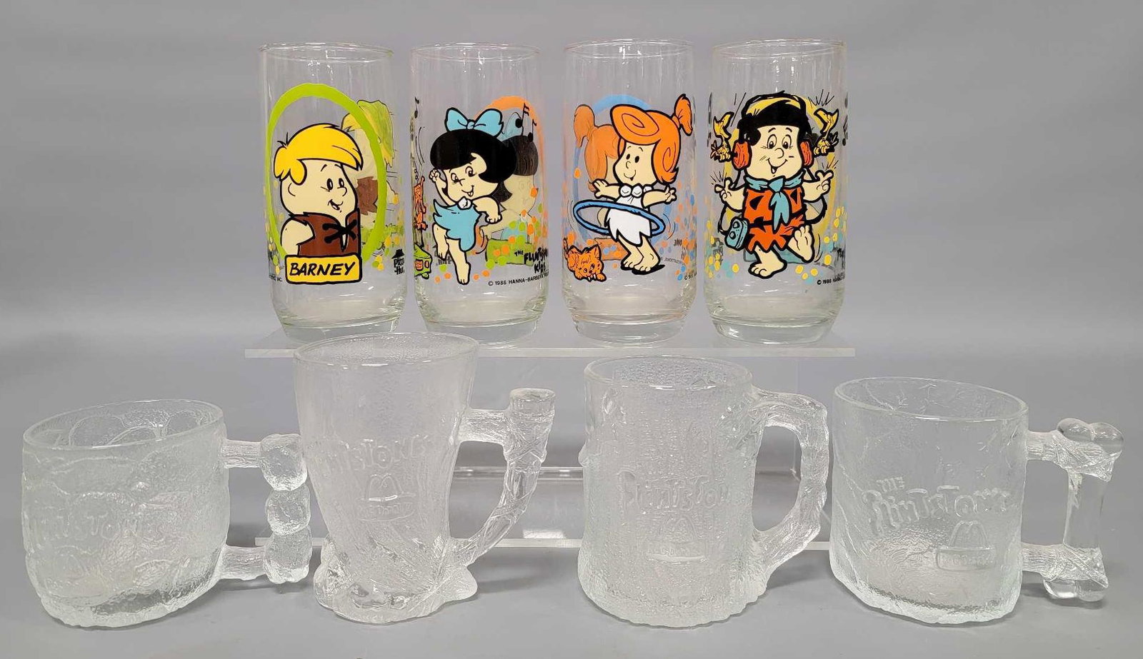 Collection of eight Flintstones collectors glasses: Collection of eight Flintstones collectors glasses, includes four Flintstones Kids from Pizza Hut and four McDonalds Flintstones mugs, all are excellent with no cracks or chips.