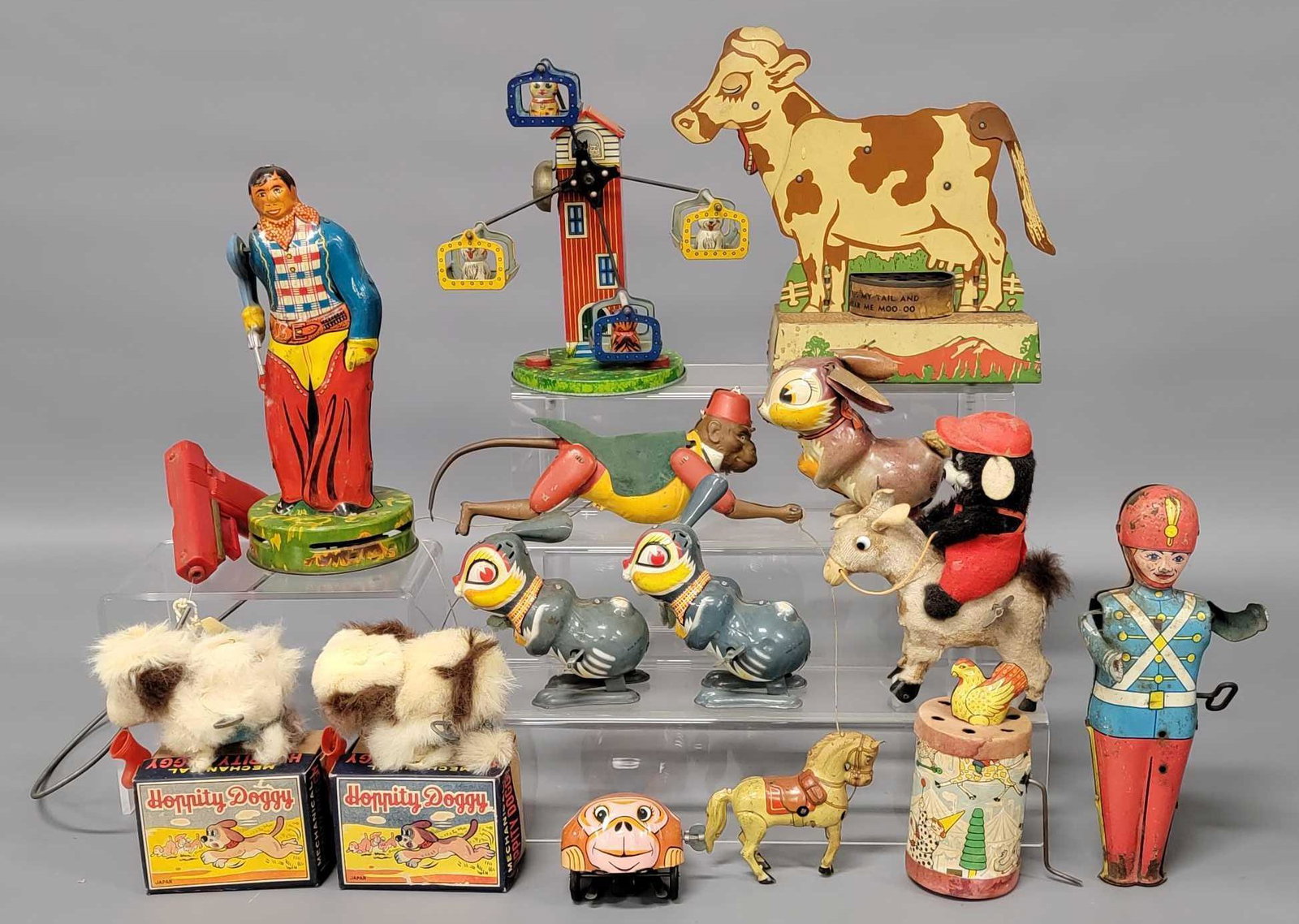 Collection of twelve tin litho toys: Collection of five tin litho toys, includes tin litho mechanical cow, it displays great but the noise box is broken, a Zippo the Monkey figure that has been totally repainted, a tin litho cowboy that 