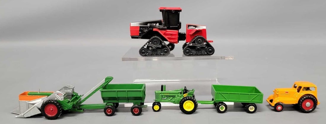 Group of 1/64 Die cast toy tractors and implements: Group of 1/64 Die cast toy tractors and implements. 1996 Farm Toy Edition Case IH Quad Trac, Oliver Row Crop 88 with New Idea two row picker and wagon, John Deere A with wagon, Minneapolis Moline Udlx