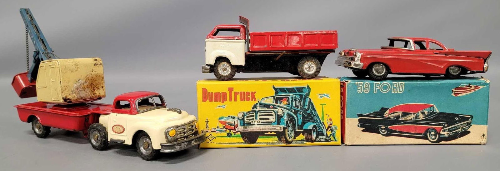 Group of three Japan friction tin car and trucks with 2 original boxes: Group of three Japan friction tin car and trucks with 2 original boxes. Daiya Japan manual dump truck in excellent condition comes in excellent original box, 59 Ford Japan tin car is in excellent plus