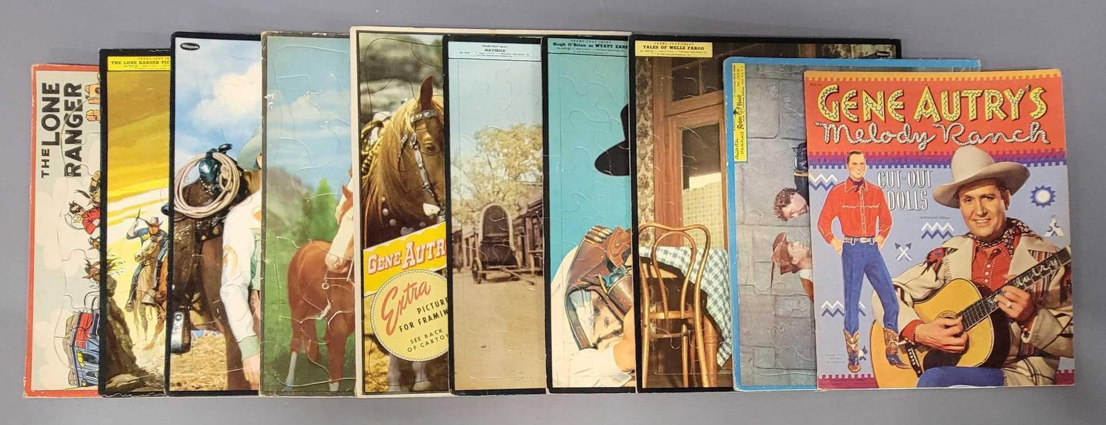 Nine vintage western star frame tray puzzles plus Gene Autry cut out dolls: Nine vintage western star frame tray puzzles to include two Lone ranger, Robin Hood, Tales of Wells Fargo, Hugh Obrien as Wyatt Earp, Maverick and three Gene Autry plus mint unused Gene Autry cut out 