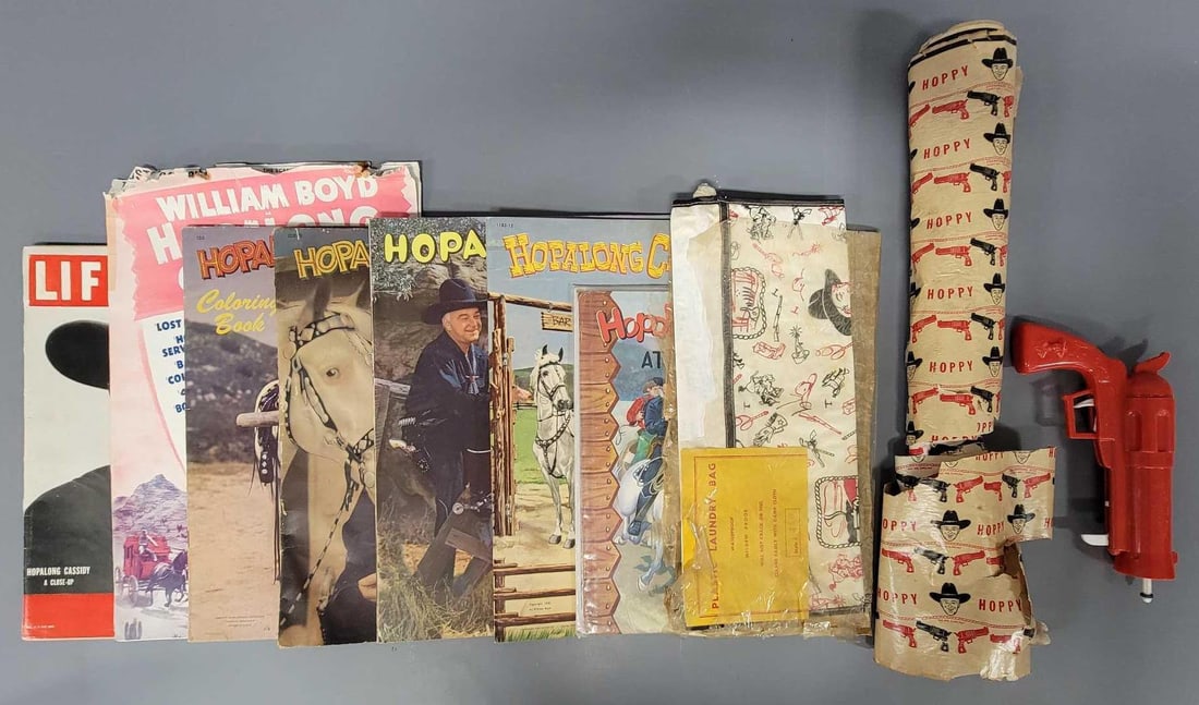 Group of vintage Hopalong Cassidy ephemera and Tigrett Zoomerang gun: Group of vintage Hopalong Cassidy ephemera to include a 1950 Life magazine, three coloring books, unused cut-out book unused plastic laundry bag in tattered package, Hoppy and Lucky at the Bar Q book 