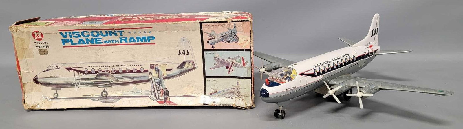 Tomy Japan tin battery operated Scandinavian air liner in original box: Tomy Japan tin battery operated Scandinavian air liner in original box in a VISUAL very good to excellent working condition with a fair to good original box that has many tape repairs as seen in the p