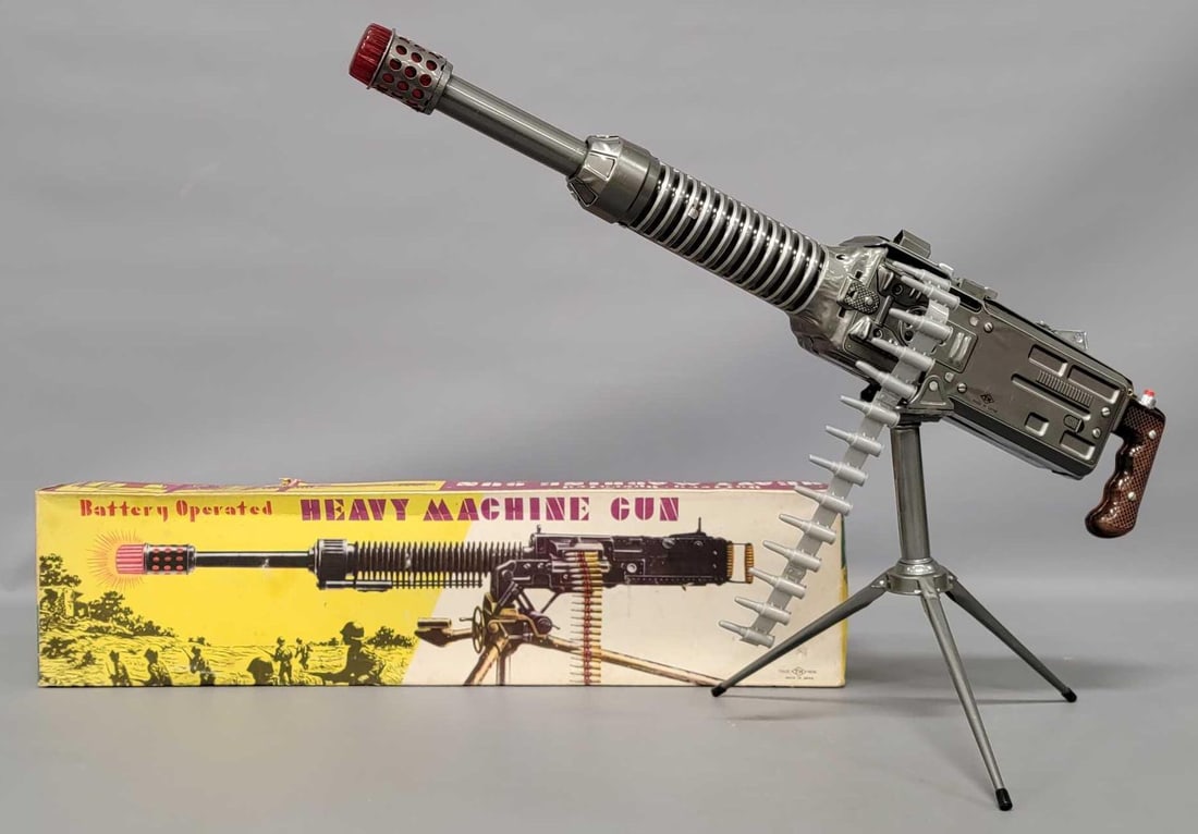 Nomura Japan tin lithographed battery operated Heavy Machine Gun in original box: Nomura Japan tin lithographed battery operated Heavy Machine Gun in original box. The toy is in excellent working condition and even feeds the ammo belt through. The ammo belt is broken in 2 places so