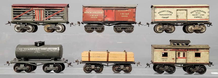 Group of six Ives 8 wheel O gauge tin freight cars: Group of six Ives 8 wheel O gauge tin freight cars to include 65 live stock transportation, 66 Standard Oil Co tank car, 67 Pennsylvania Lines caboose, 68 Merchants Despatch reefer, 69 flat car with l