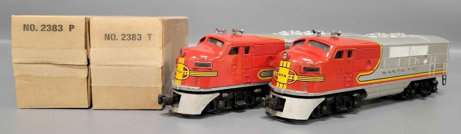 Two Lionel postwar O 2383 Santa Fe F-3 AA powered diesel locomotives: Two Lionel postwar O 2383 Santa Fe F-3 AA powered diesel locomotives with reproduction boxes. Units show heavy run time and are C6-7 with no battery damage as seen in the photos.