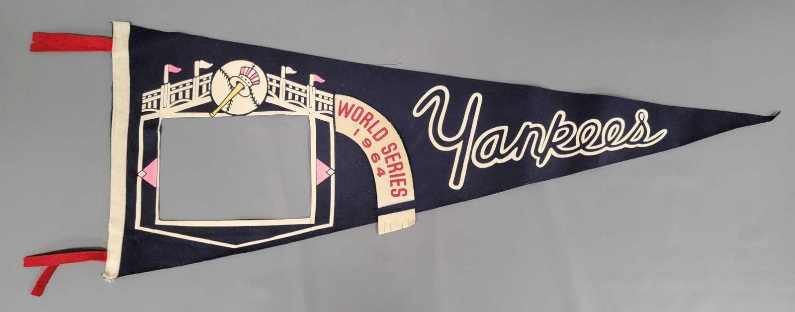 New York Yankees 1964 World Series felt pennant: New York Yankees 1964 World Series felt pennant that is missing the photograph of the World Champion Yankees, otherwise in nice shape, measures 29 1/2 inches long as seen in the photos.
