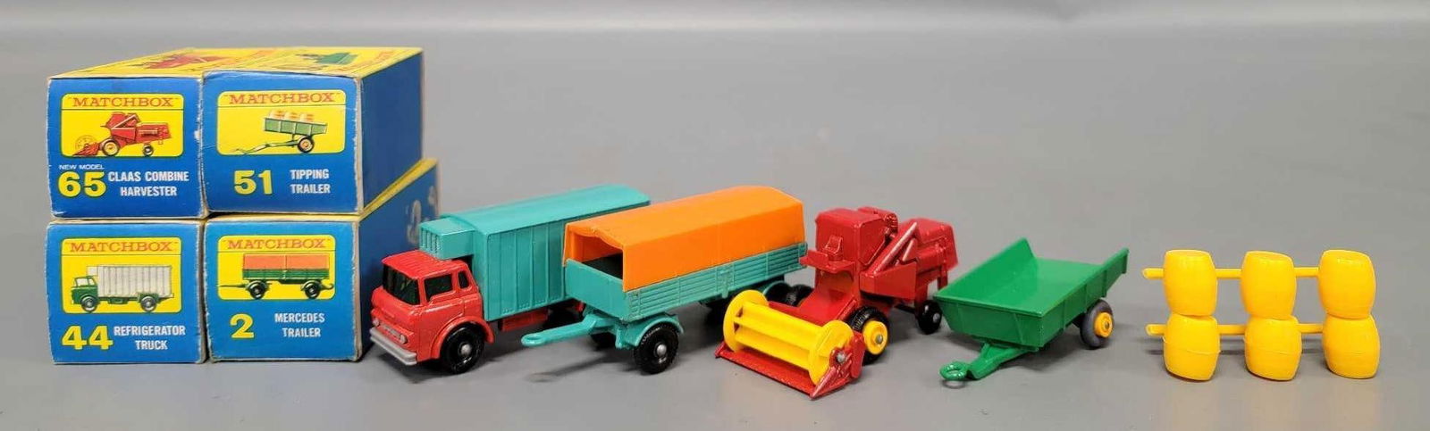 Four Matchbox cars in original boxes: Four Matchbox cars. Consists of No 2 Mercedes Trailer with black plastic wheels, No 44 Refrigerator Truck with black plastic wheels, No 51 Tipping Trailer with gray plastic wheels, barrels on sprue. A