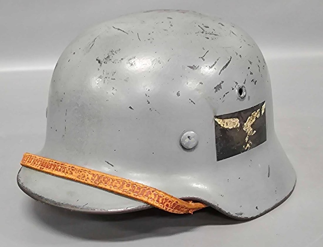 German Luftwaffe helmet painted battleship gray: German Luftwaffe helmet painted battleship gray with a nice decal on one side but the leather strap is missing a button on one side and is being held together with a small piece of very thin copper wi