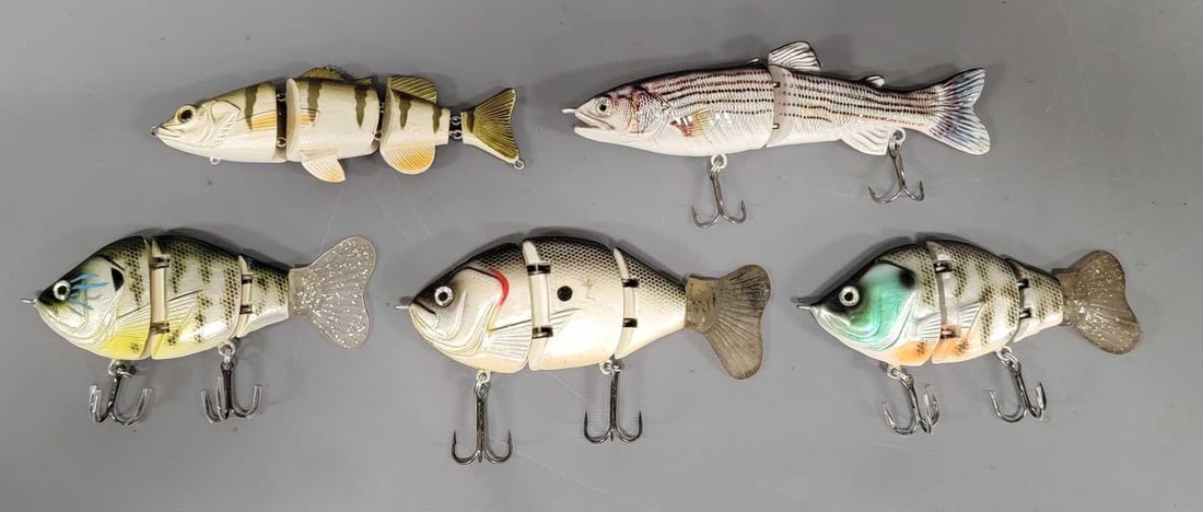 Five hard swim bait fishing lures: Five hard swim bait fishing lures. Consists of three hard swim baits with soft tails and two hard swim baits on with no hooks one with a missing fin in near mint condition as seen in the photos.
