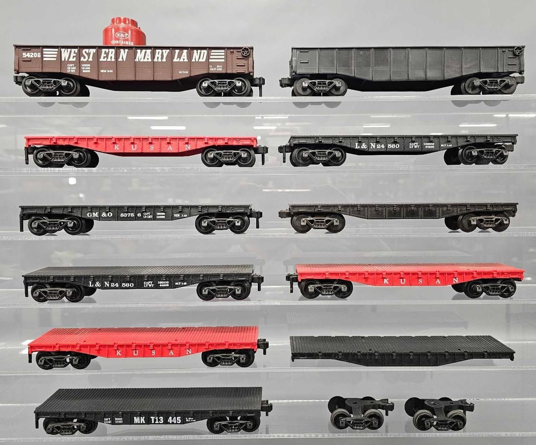 Group of eleven Kusan KMT O gauge flat cars and gondolas: Group of Kusan KMT O gauge flat cars and gondolas. Includes one unmarked black, three red KUSAN, two Louisville and Nashville, one MKT and one Gulf, Mobile and Ohio flat cars that are complete plus an