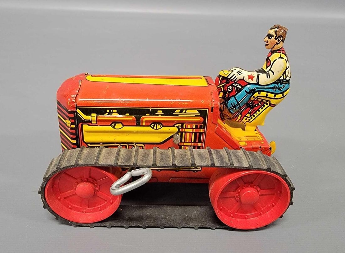 Marx tin lithographed wind-up farm dozer with figure: Marx tin lithographed wind-up farm dozer with figure, C6 and does work. Measures 5 inches long.