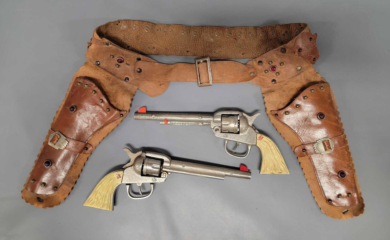 Kilgore Long Tom cast iron cap guns with double holster: Kilgore Long Tom cast iron cap guns with double holster. Both work perfectly and are very clean. The holster is still soft but the loops that hold the toy bullets in place are flattened out but are ma