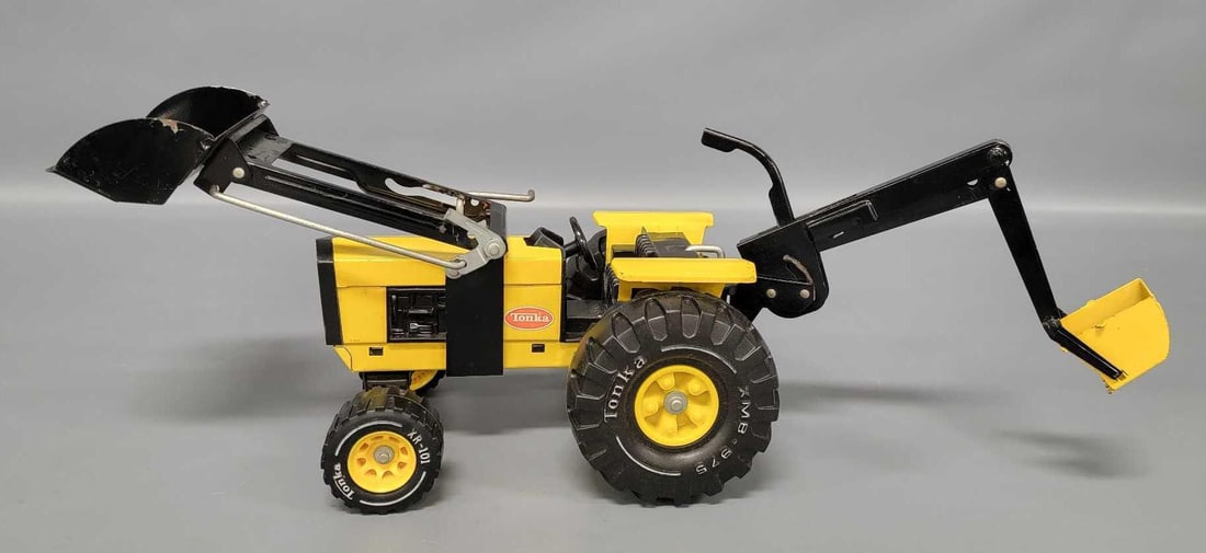 1970's Tonka pressed steel farm tractor with loader and backhoe: 1970's Tonka pressed steel farm tractor with loader and backhoe, shows some play wear with minor paint loss and a faded label.