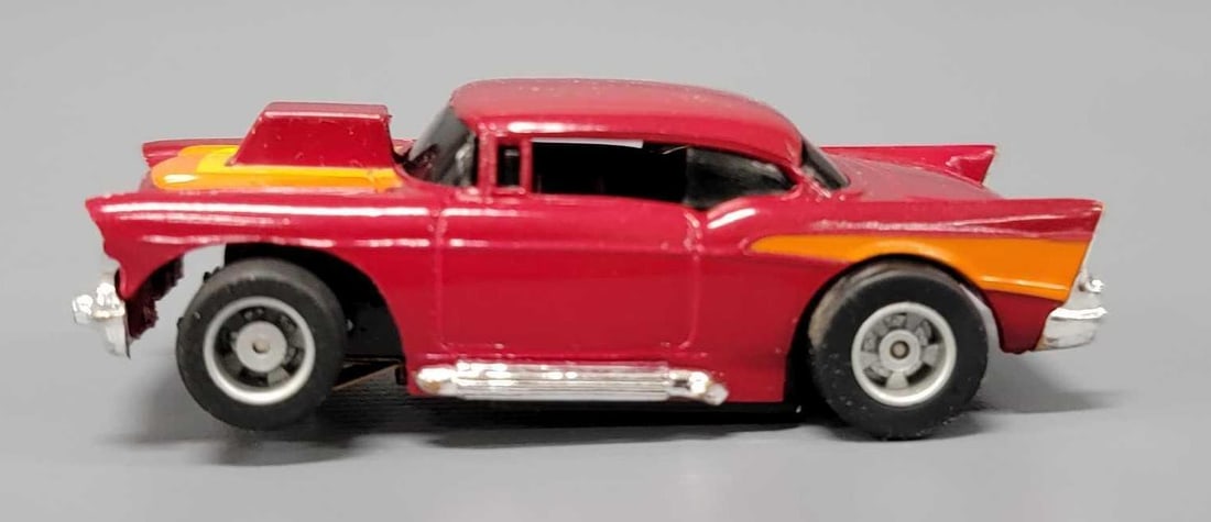 Tyco 57 Chevy HO slot car: Tyco 57 Chevy HO slot car, maroon with orange and yellow stripes, unrun chassis. This has been tested with a 9 volt battery and runs perfectly.