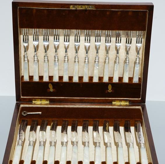 WALKER & HALL SILVER & MOTHER OF PEARL FISH SET: Walker and Hall mother handled fish set. Silver engraved blades and forks. Silver banded. set of 12 . knives 7" forks 5 3/4" Hallmark on the blade W&H S K W & H in a flag. Type B dating to late 19th c