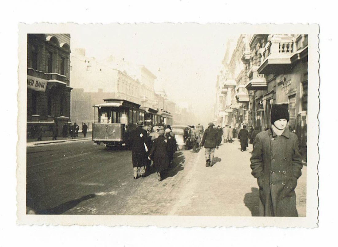 Litzmannstadt - Photo - Jews on Street Pavement 1940: Period photo showing Jews walking along the pavement of the Adolf Hitler Strasse in Litzmannstadt in February 1940. We can see also the tramway that circulated in Lodz at that time. Jews are wearing t