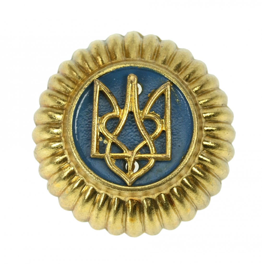 Ukrainian Schutzmannschaft units' cap cockade: Ukrainian Schutzmannschaft units' cap cockade. Stamped two-piece alloy construction cap cockade with stylized trident for Ukrainian auxiliary police units (German: Schutzmmanschaft) in Galicia (Ukrain