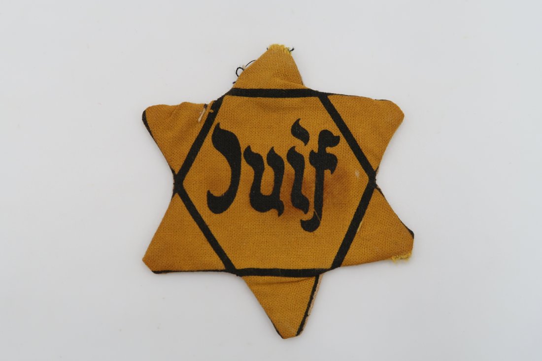 JUIF Star of David Badge: JUIF Star of David Badge, one of the rarest varieties of the badge. The French JUIF star is nearly impossible to come by. This one is a used variety with a cloth sewn to the back. The owners of these 