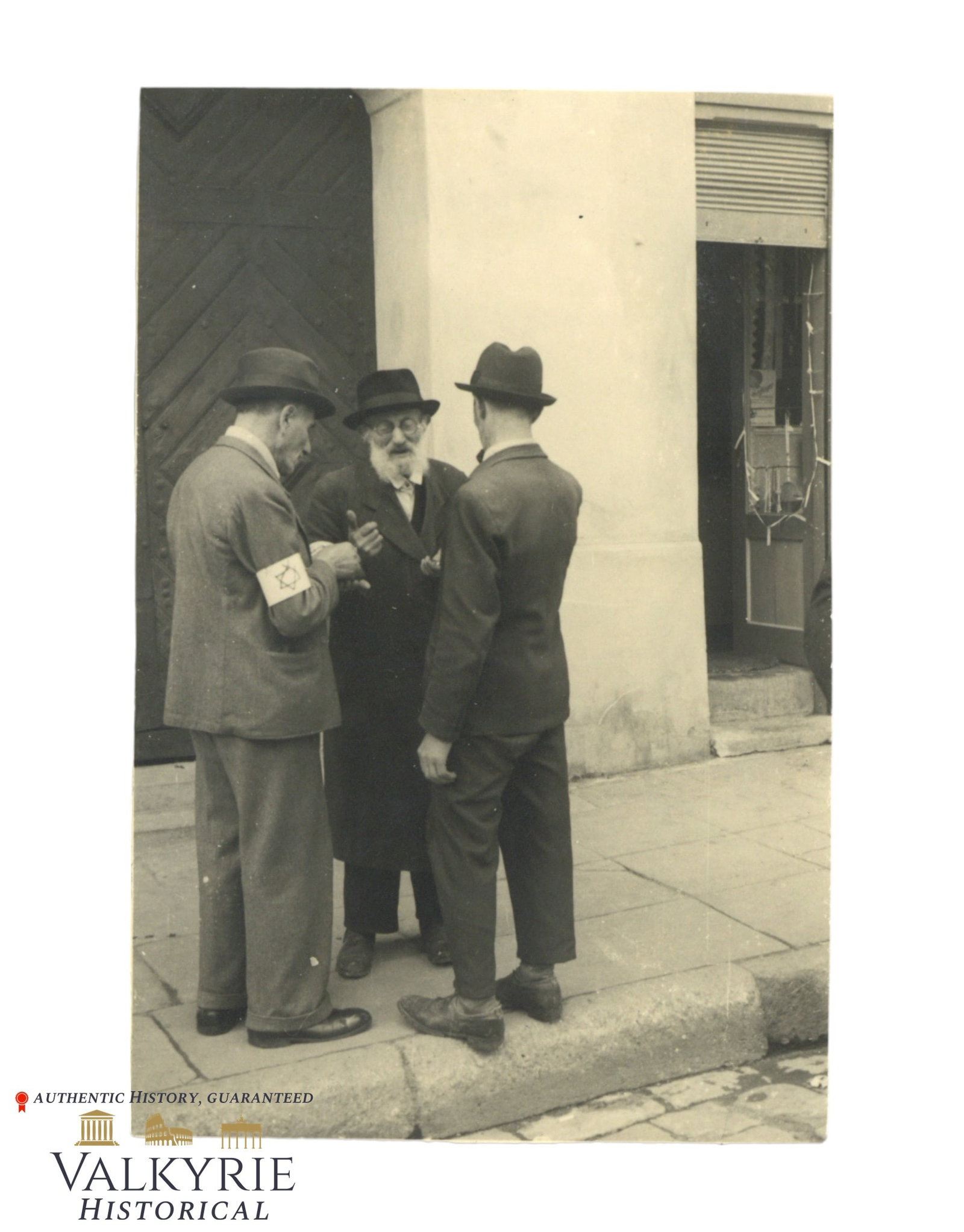 Photo of Some Jewish Men Talking in the Street in the Jewish Ghetto of Tarnow in 1941: Photo of Some Jewish Men Talking in the Street in the Jewish Ghetto of Tarnow (Poland) in 1941. Described on the reverse. We can see one of the Jews wearing the armband with the star of David. Size: 9